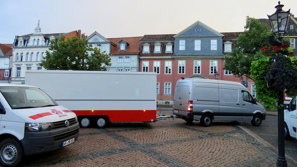 Ein Verkaufswagen auf dem Wochenmarkt wird von einem Auto auf dem Stadtmarkt in Wolfenbttel in die richtige Stellung gezogen.